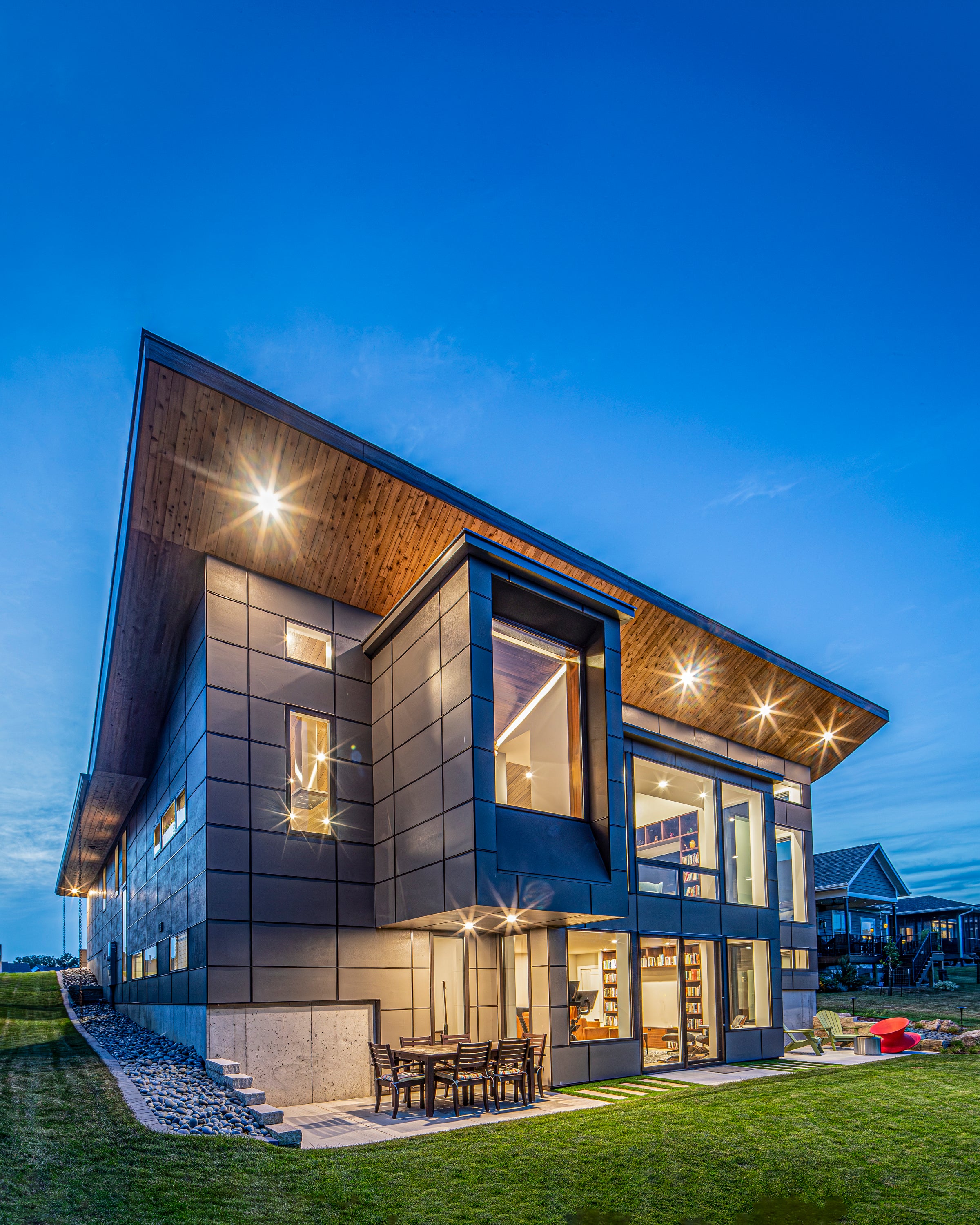 Modern house exterior with illuminated windows at dusk